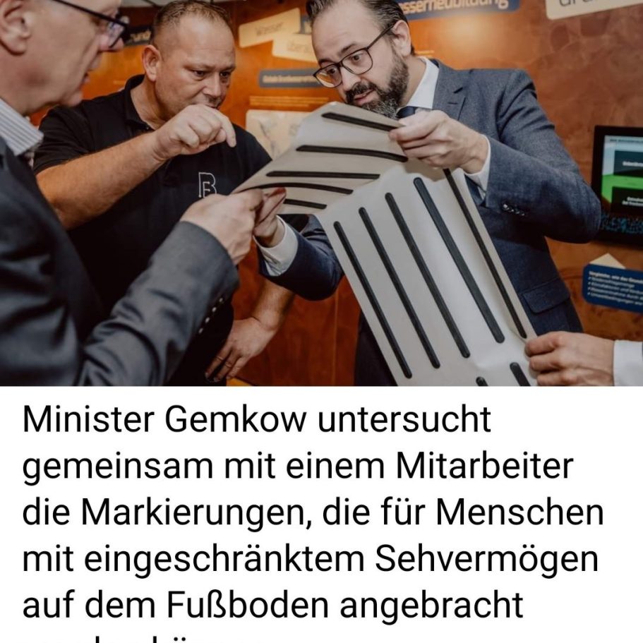 Minister Gemkow prüft zusammen mit einem Mitarbeiter Markierungen für Menschen mit Behinderungen.
