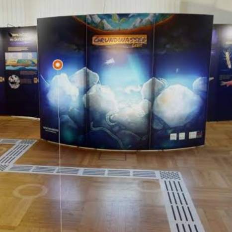 Interaktive Ausstellung mit bunten Grafiken und einem großen, beleuchteten Bildschirm.